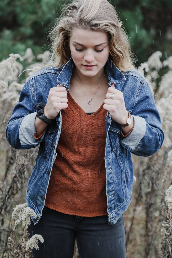 Front view of vintage blue denim jacket with button closure and folded cuffs