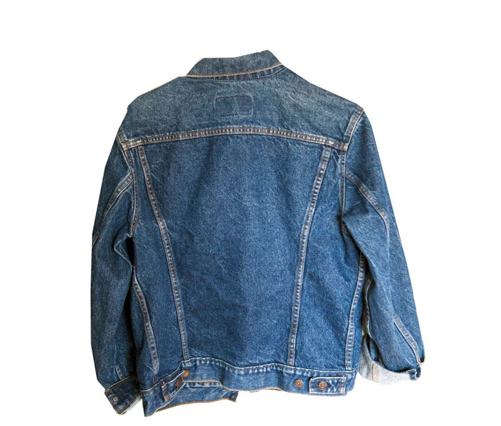 Front view of vintage blue denim jacket with button closure and folded cuffs