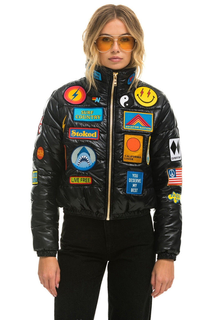 Vintage black glossy puffer jacket with colorful embroidered patches
