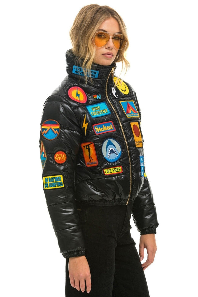 Vintage black glossy puffer jacket with colorful embroidered patches
