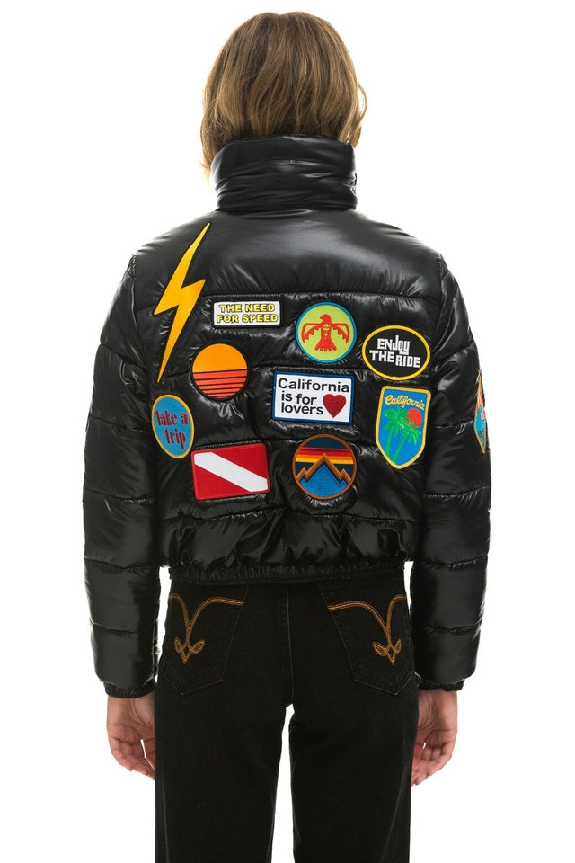 Vintage black glossy puffer jacket with colorful embroidered patches
