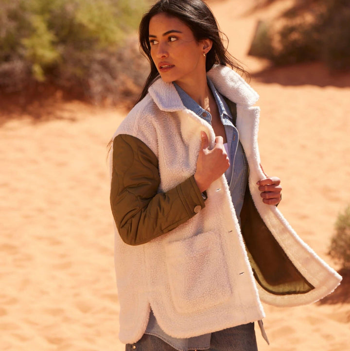 Women’s green quilted mixed media jacket with faux shearling and quilted sleeves.
