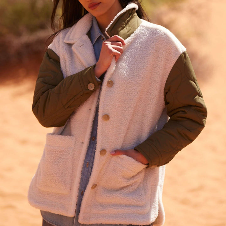 Women’s green quilted mixed media jacket with faux shearling and quilted sleeves.
