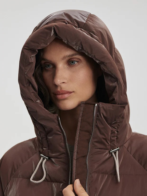 Person wearing a brown winter coat, leggings, and boots 