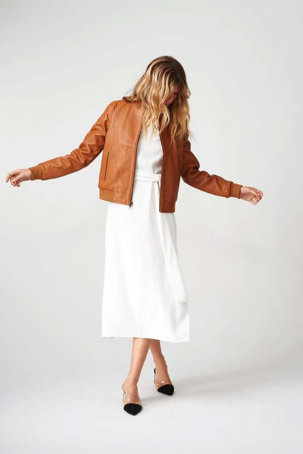Woman wearing Women’s Bolzano Bomber Leather Jacket outdoors, styled for casual spring/autumn adventures